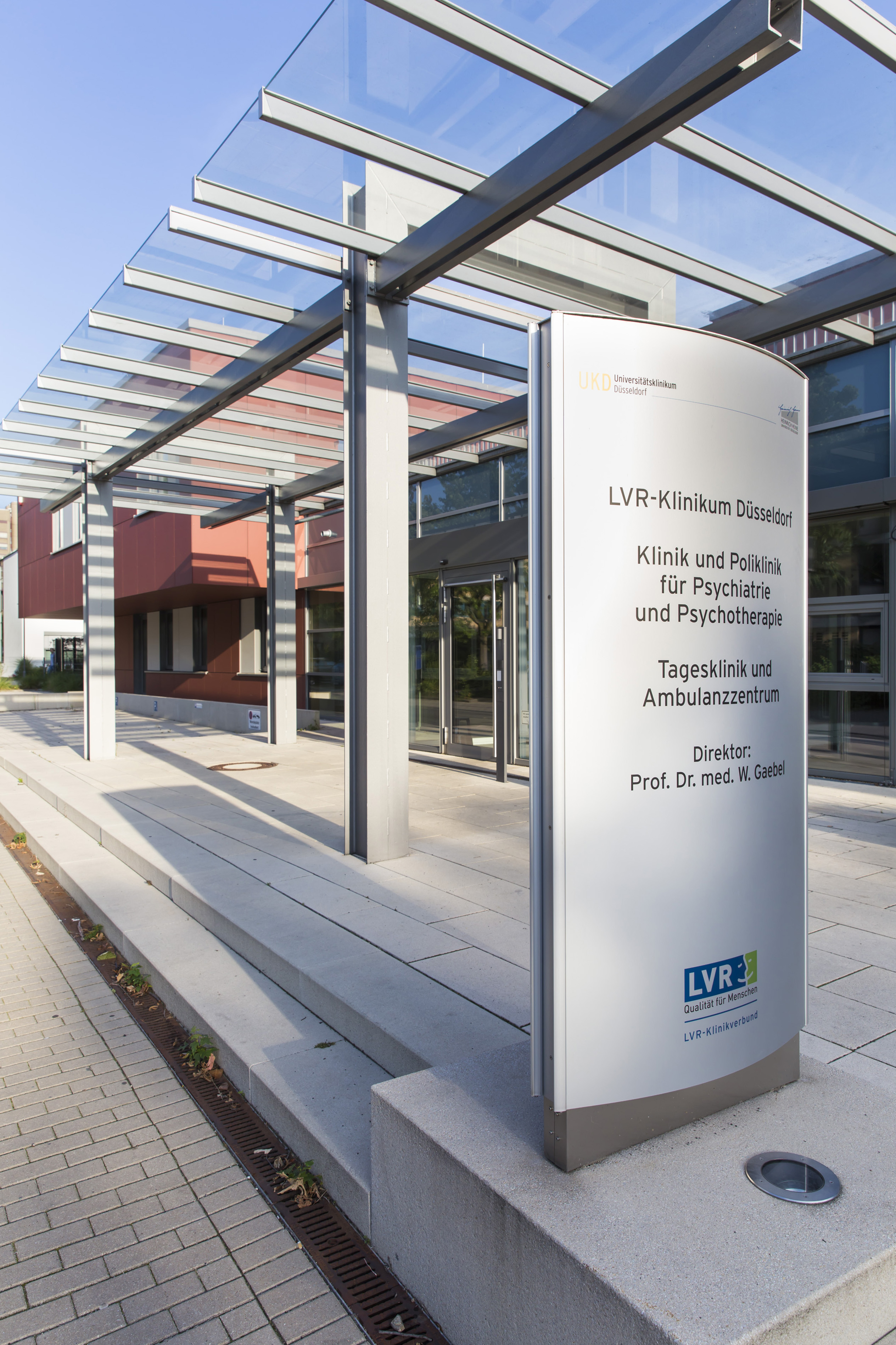 Bild von einem Haus mit einem Glasvordach, Schild auf dem Tagesklinik und Ambulanzzentrum steht